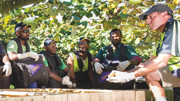 [image] Group of workers gathered round listening to instructions from manager