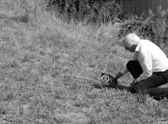 [Image] Man measuring a slope with a ruler.  